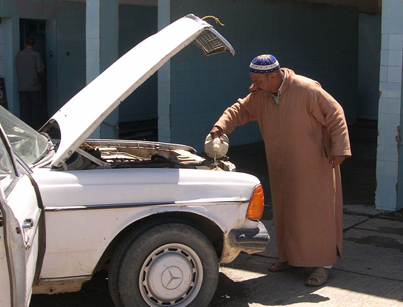 Our Taxi Driver filling the radiator with water after overheating.