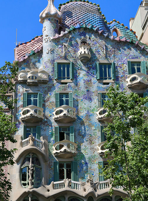 The vibrant facade of Antoni Gaudi's Casa Batlló on Passeig de Gràcia, Barcelona, with its distinctive balconies and mosaic work.