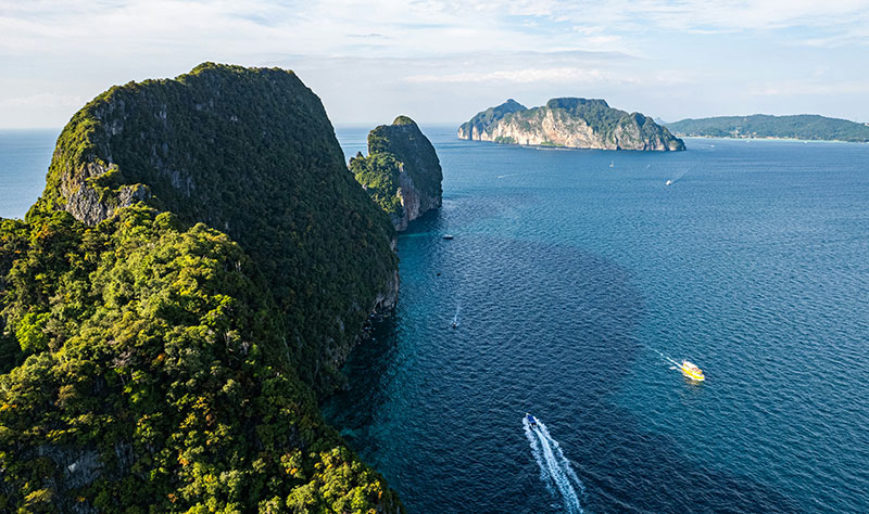 Limestone cliffs rising from the blue water at Koh Phi Phi Leh in Thailand.