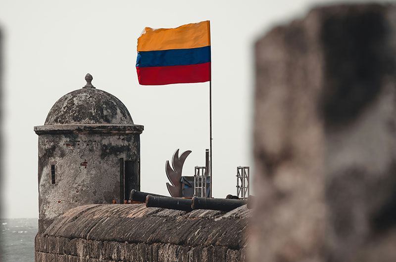 Colombian flag flying over the historic Castillo San Felipe de Barajas in Cartagena, Colombia.