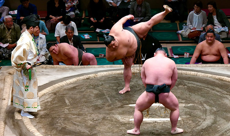 wo sumo wrestlers engaged in a match at the Ryogoku Kokugikan in Sumida City, Tokyo, Japan.