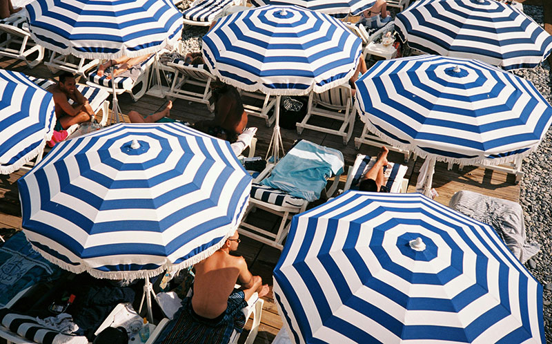 Beach umbrellas in Nice, France, are iconic, especially the blue-and-white striped ones at private beach clubs