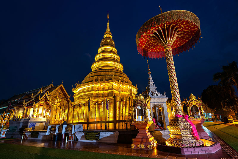 Night view of the illuminated golden Phra Si Ratana Chedi at Wat Phra Kaew (Grand Palace) in Bangkok.