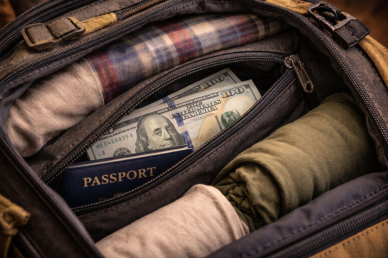 A hidden pouch with emergency cash and a passport inside a travel backpack.
