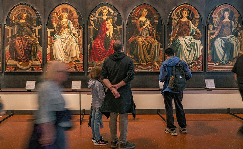 A view inside the Botticelli room at the Uffizi Gallery, featuring the large Primavera painting on the wall.