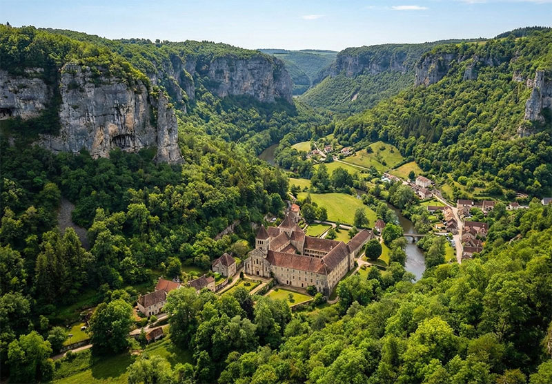 The steep limestone cliffs and abbey of Baume-les-Messieurs in the Jura mountains of France.