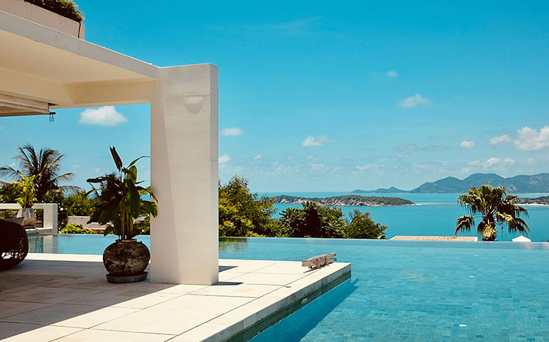 Luxury infinity pool at Samujana Villas in Koh Samui overlooking the ocean and distant islands.