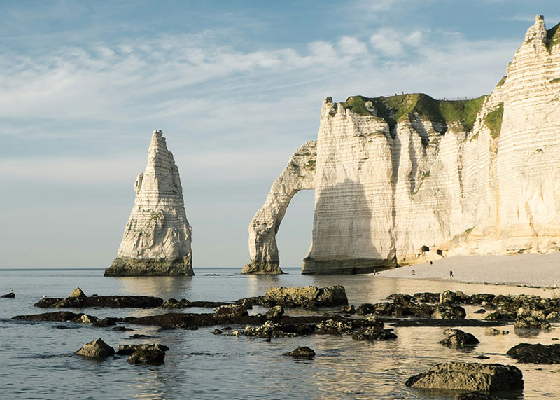 he dramatic chalk cliffs and natural arch at Étretat on the Normandy coast.