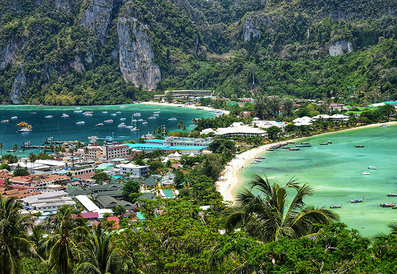 Scenic view from the Koh Phi Phi Don viewpoint showing the isthmus between Tonsai Bay and Loh Dalum Bay with limestone cliffs in the background.