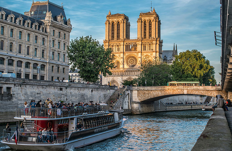 View of Notre Dame cathedral from the Seine river in Paris, with boats
