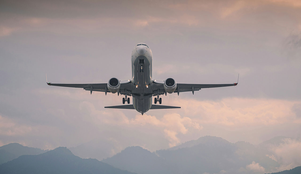 A jet plane taking off into a dusky sky, symbolizing the start of an international journey.