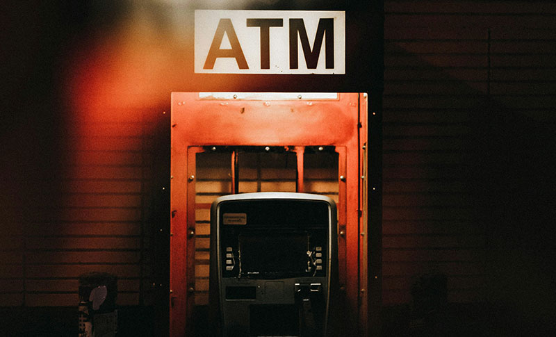 ATM Machine in dark background and sign ATM above.