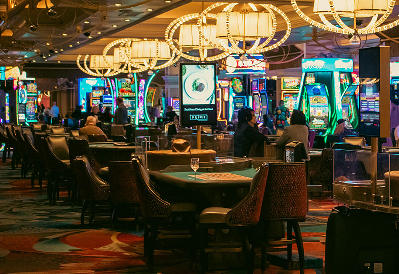 Alt Text: A close-up view of a blackjack table at the Bellagio Resort & Casino, showing the green felt layout, playing cards, and colorful betting chips under warm overhead lighting.
