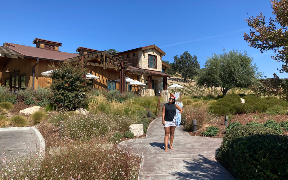 Visitor standing on the pathway outside the tasting room at Halter Ranch winery in Paso Robles.