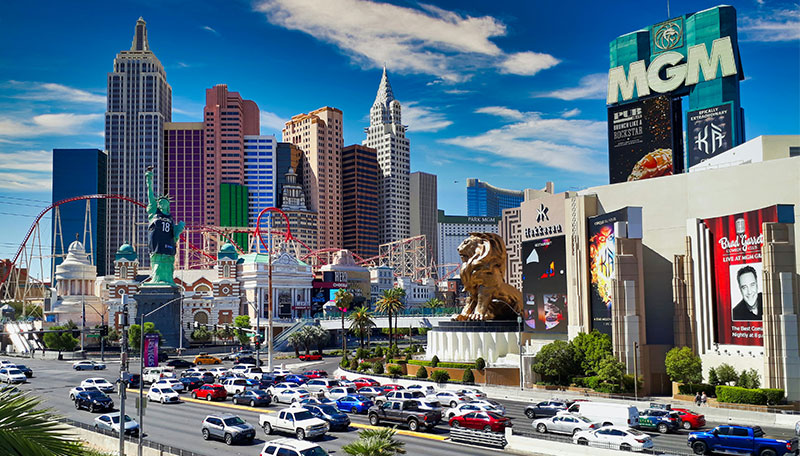 A colorful graphic overlay of iconic Las Vegas Strip landmarks, including the New York-New York skyline and MGM Grand, representing a comprehensive guide to finding travel deals.