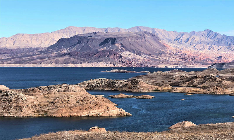 A wide scenic view of the desert landscape at Lake Mead National Recreation Area near Las Vegas, featuring rugged mountains and the blue waters of the lake under a clear sky.