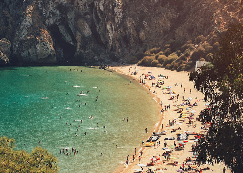 High-angle view of Quemado Beach in Al Hoceima, Morocco with turquoise water and cliffs.