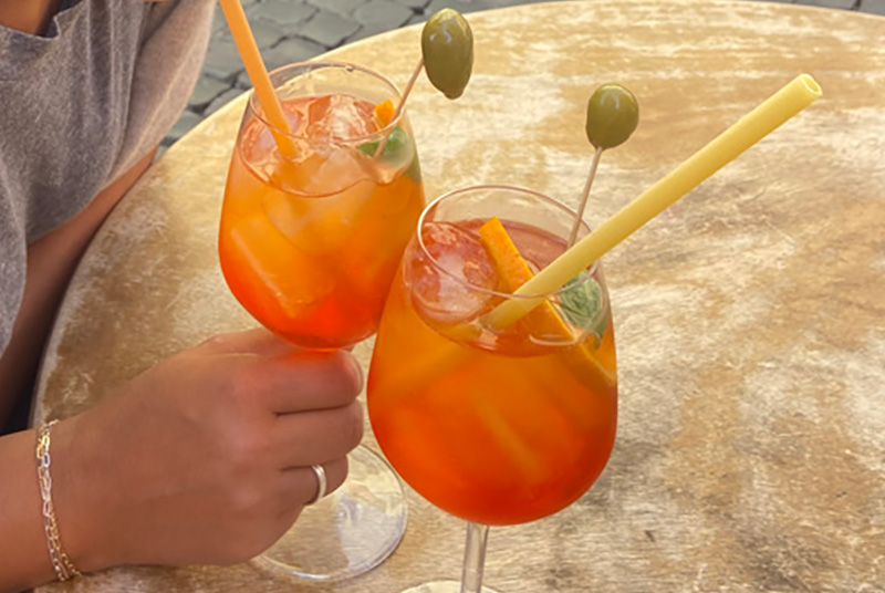 Two Aperol spritz cocktails on a café table during aperitivo in Italy