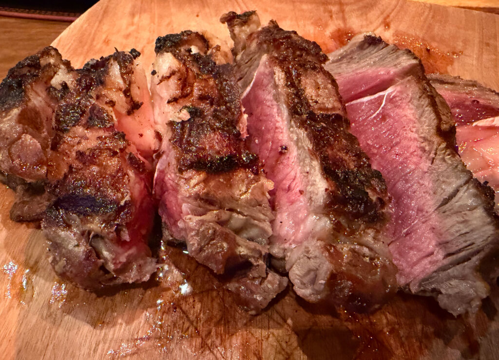 Bife de chorizo ribeye steak sliced medium rare with charcoal grill marks at Asador La Vaca Argentina in Mazatlán