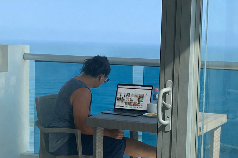Digital nomad working on a laptop from a Bocagrande Cartagena balcony overlooking the ocean