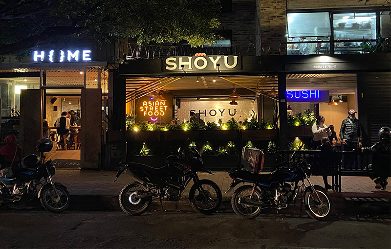 Restaurants and street scene at night in Zona G Bogotá with motorcycles parked outside