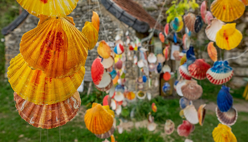 A hanging display of brightly painted scallop shells, the traditional symbol of the Camino de Santiago pilgrimage.