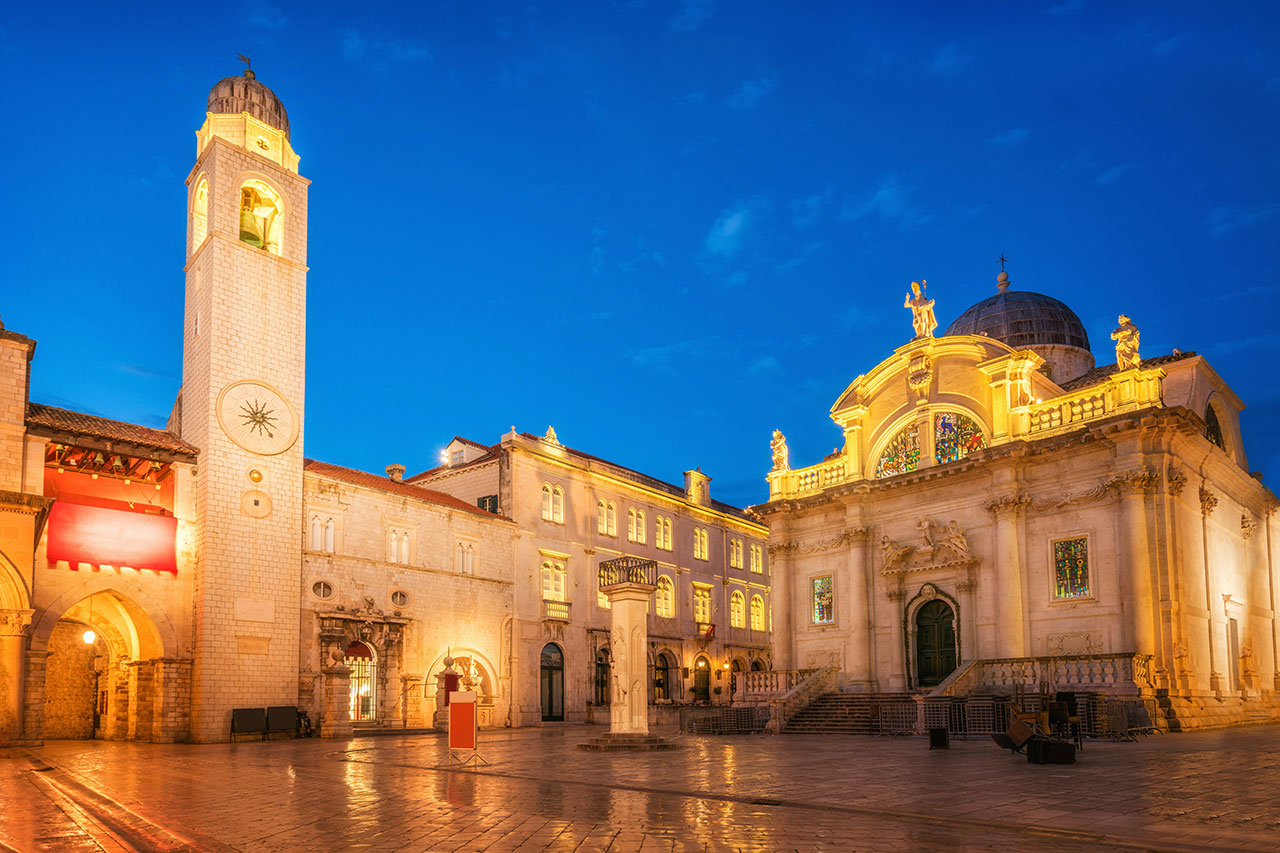 Illuminated stone architecture of Luza Square and St. Blaise Church at night in the walled Old Town of Dubrovnik, Croatia.