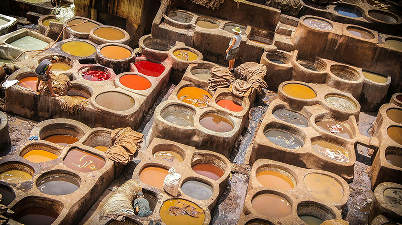 rows of circular stone vats filled with colorful dyes at the leather tannery in Fez.