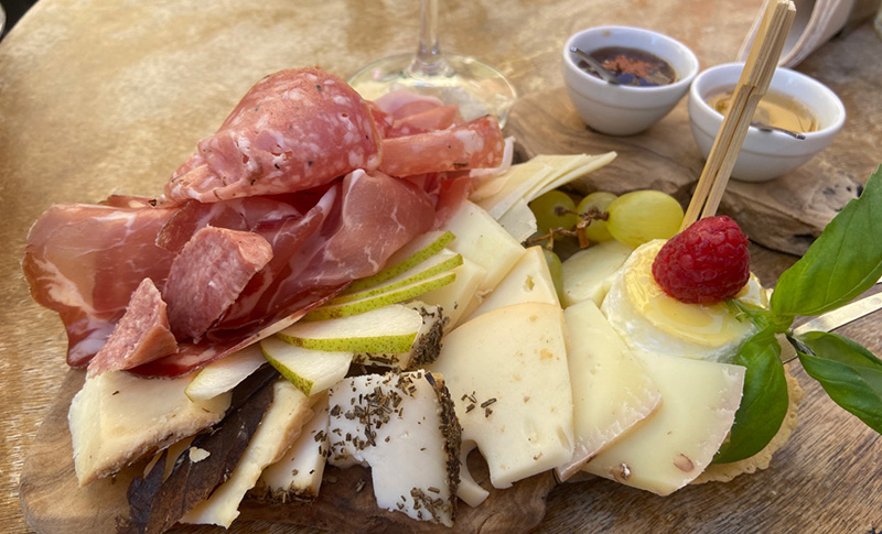 Italian aperitivo board with cured meats, cheeses, fruit, and spreads on a wooden platter
