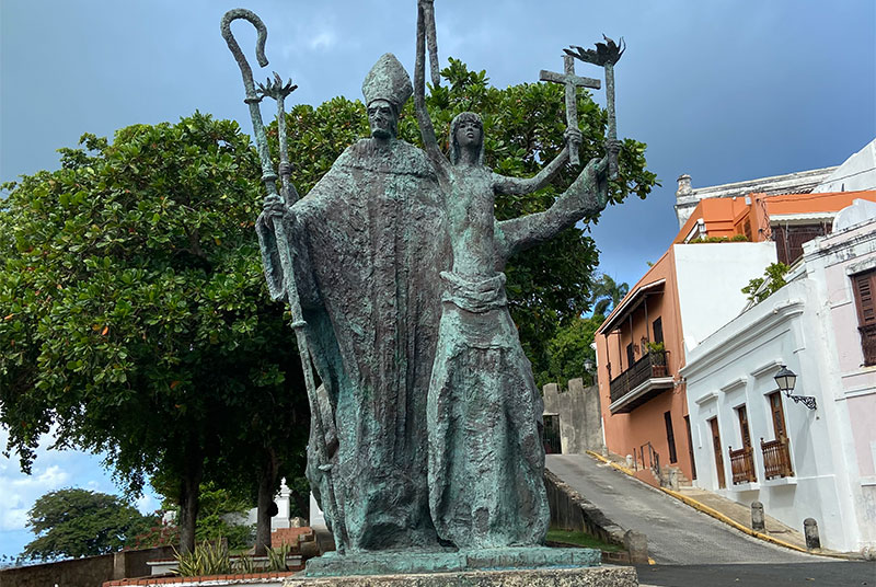 A bronze monument known as La Rogativa featuring a bishop and a woman holding a torch in Old San Juan