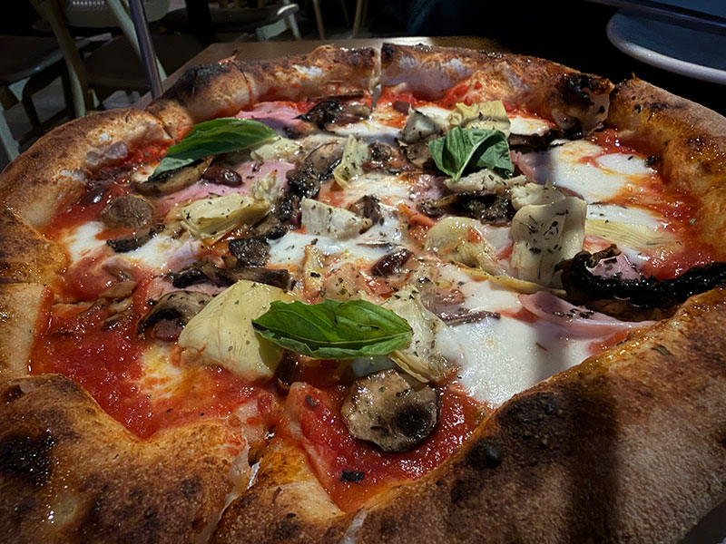 Wood fired pizza with salami, artichokes, mushrooms, and olives at La Sagrada Pizzeria in Mazatlán.