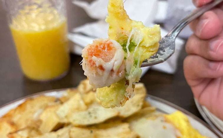 A close-up of a classic breakfast dish at Omelet House, featuring a fluffy omelet served with golden-brown hash browns and a side of thick-cut toast