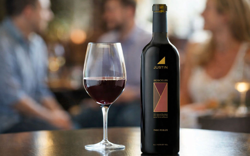 JUSTIN Isosceles Paso Robles red wine bottle with a glass of wine at a tasting table