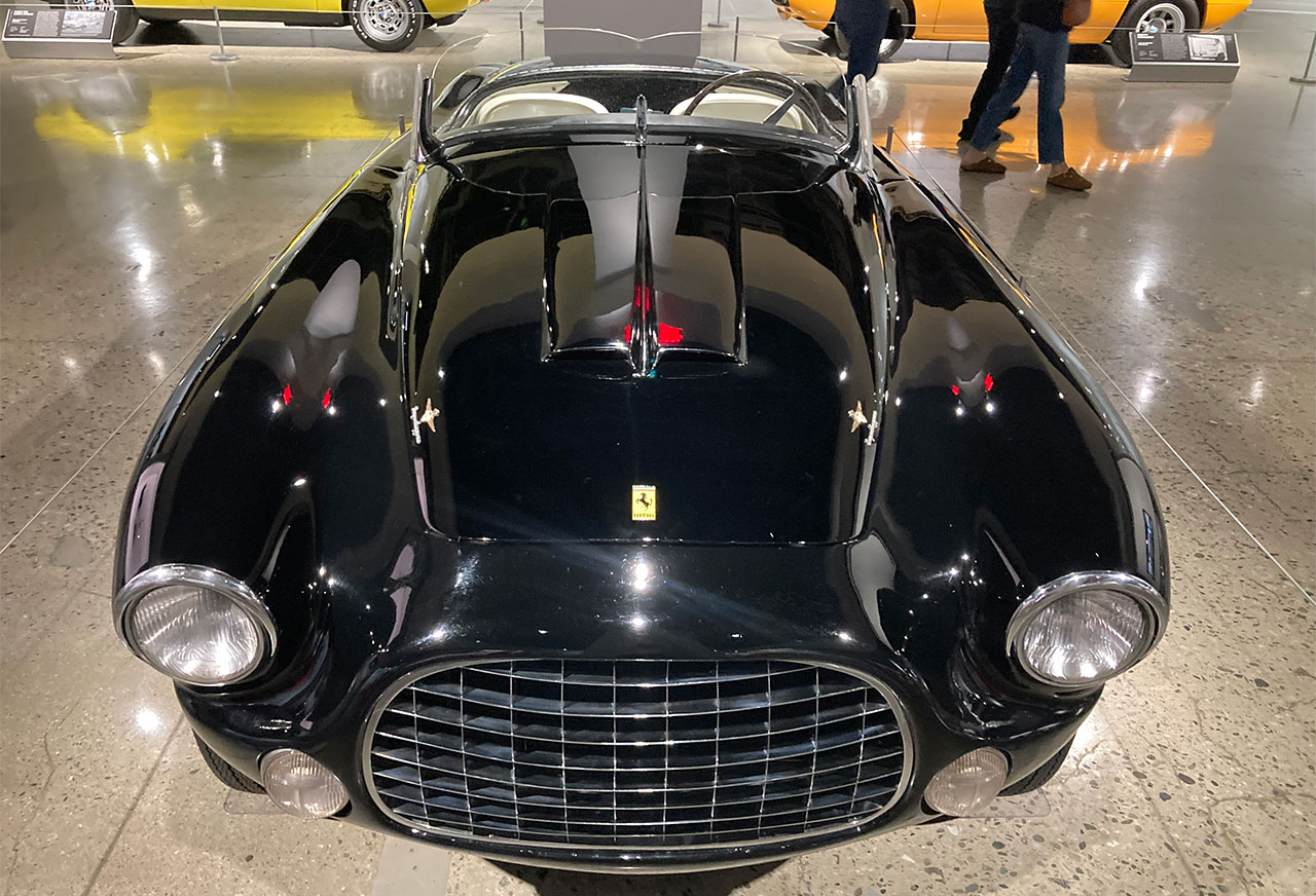 ront view of a vintage black Ferrari with a distinctive grille at the Petersen Automotive Museum in Los Angeles.