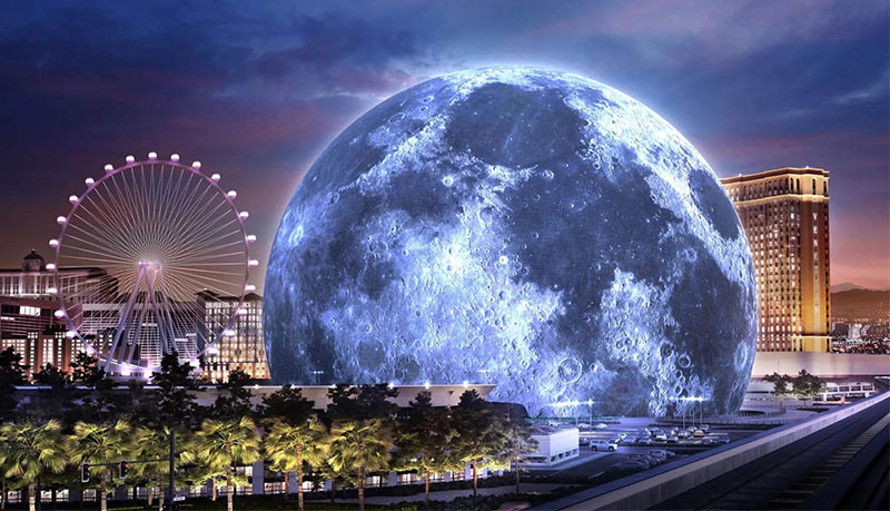 A massive, immersive curved LED screen illuminating the interior of The Sphere in Las Vegas during a live show, with a silhouetted audience watching the vibrant visuals from their seats.