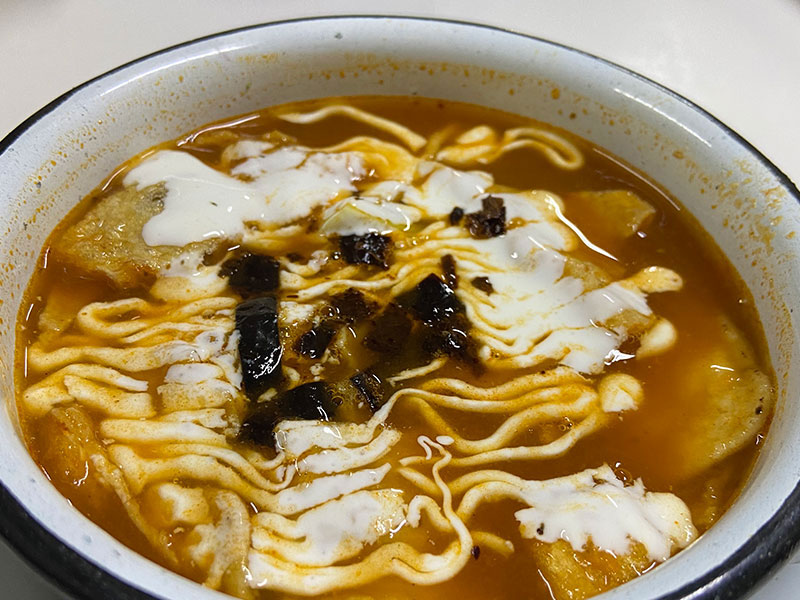 Bowl of traditional Mexican tortilla soup with cream and crispy tortilla strips.