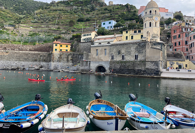 Small boats in the harbor below colorful hillside buildings in Vernazza, Cinque Terre