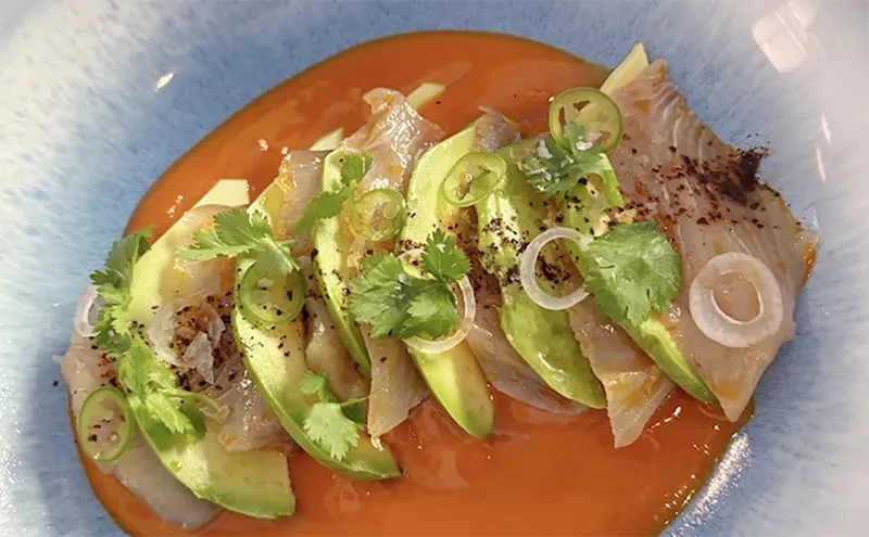 A plate of fresh sashimi topped with sliced peppers and garnishes at Nao Kitchen Bar in Mazatlán.