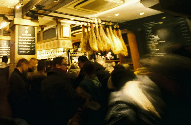Traditional Basque bar counter packed with an assortment of vibrant pintxos under warm lighting in San Sebastián.