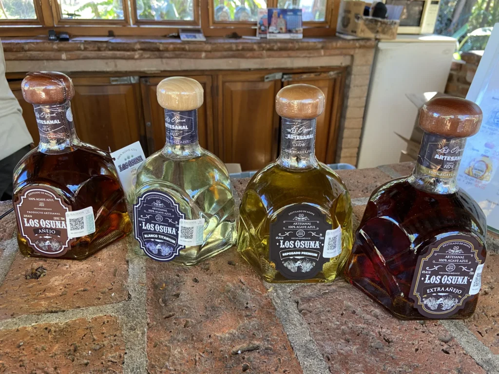 Osuna agave-spirit bottles displayed on a wooden counter.