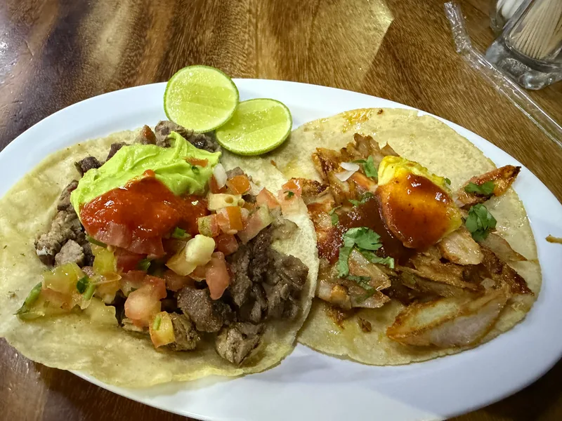 A plate of grilled meat tacos served with fresh guacamole and lime wedges at Pancho's Restaurant in Mazatlán.