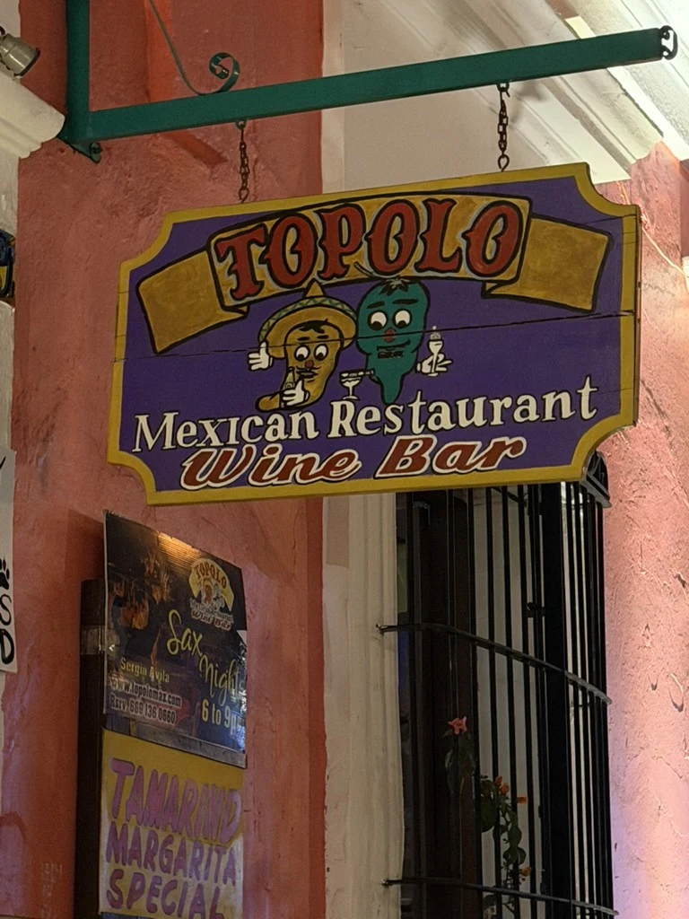 Topolo Mexican Restaurant and Wine Bar sign beside the entrance at Topolo in Mazatlán.