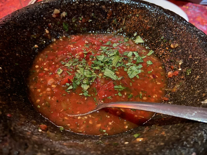 Fresh red salsa with herbs in a stone bowl at Topolo in Mazatlán.